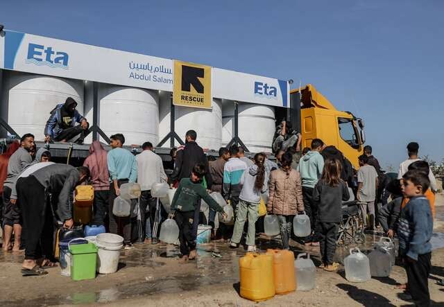 사람들이 물 공급 트럭에서 물을 받기 위해 몰려 있습니다.